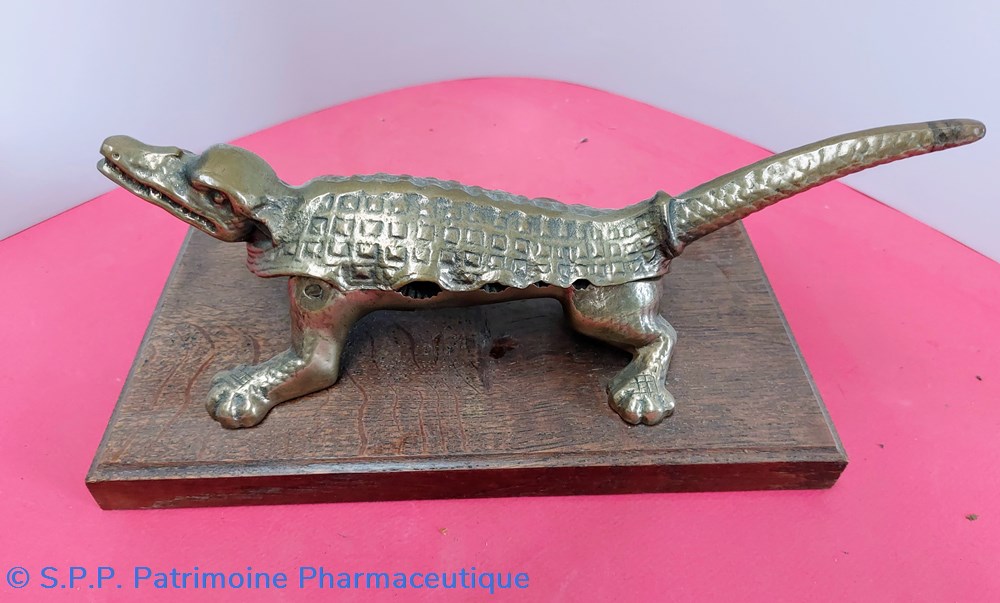 science pharmacie mache bouchons sur socle crocodile en bronze