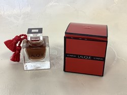 « Le parfum » LALIQUE eau de parfum. Flacon à l’état neuf avec son cordon rouge, 4,5 ml dans sa boîte, en bon état.