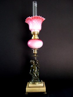 Lampe toupie à pétrole, sur bougeoir à putti en bronze, sur socle de marbre