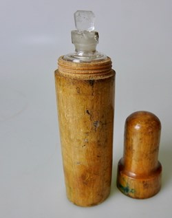 Fiole en verre insérée dans un étui en bois