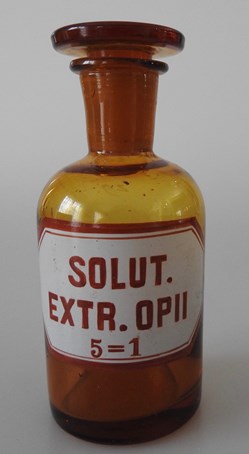 Flacon de pharmacie en verre ambré petit modèle à étiquette blanche et rouge, forme bouteille