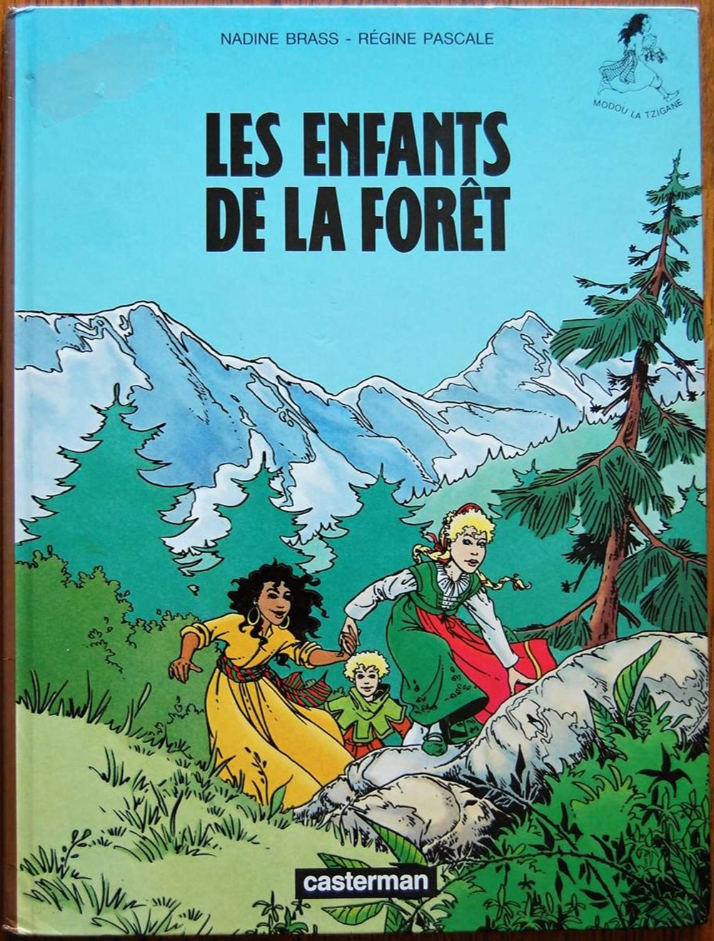 BD - Modou la tzigane Modou la Tzigane est une série de Bande Dessinée, contant les aventures d'une jeune Tzigane à la fin du Moyen âge. Scénarisée par Régine Pascale et dessinée par Nadine...
